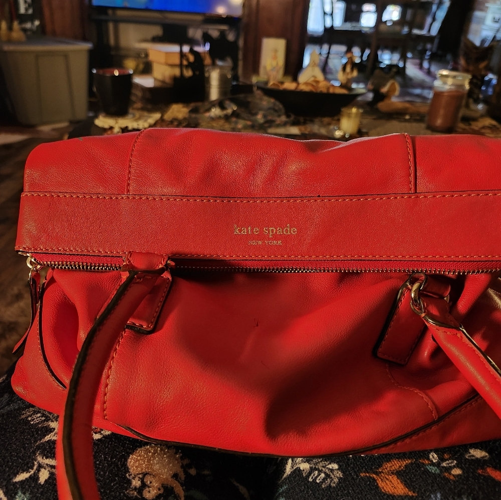 Kate spade red purse with top zip and shoulder strap.